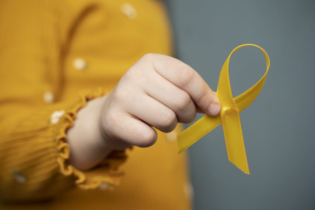 child holding yellow ribbon