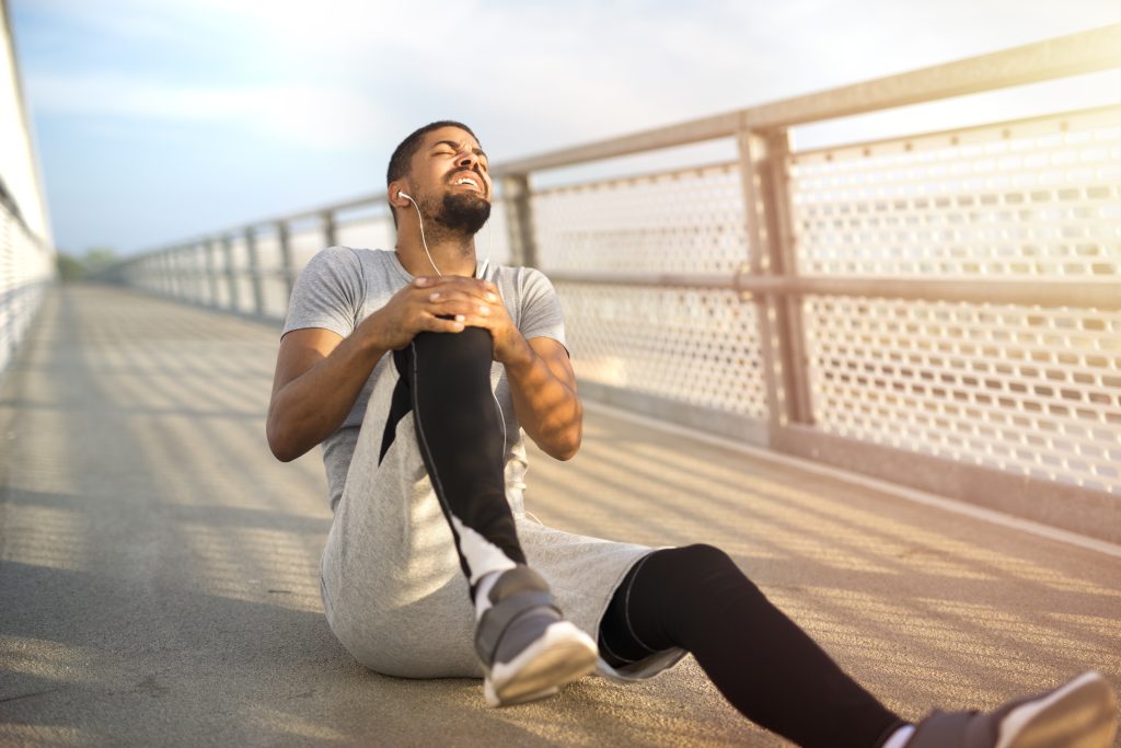 Beneficios del deporte y la actividad física: cómo mejorar tu vida y prevenir lesiones 5 sportsman having knee injury problem running training