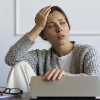 vista-frontal-mujer-que-trabaja-en-la-computadora-portatil